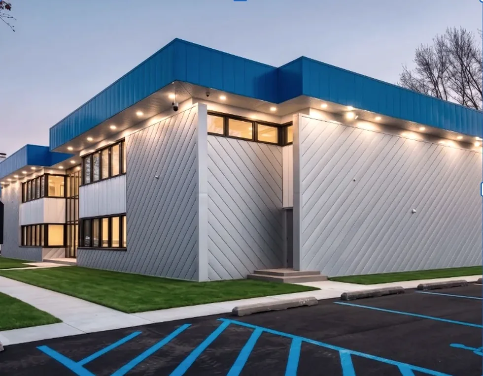Architectural corner of a modern company building with warm exterior lighting